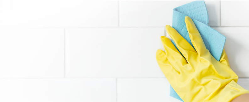 stock photo of someone cleaning a bathroom wall from canva for our Bathroom drains blog